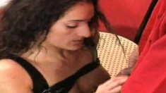 In a kitchen a sexy brunette playing with her big boobs