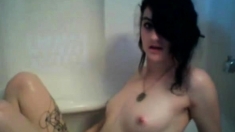 Goth teen playing in the bathtub