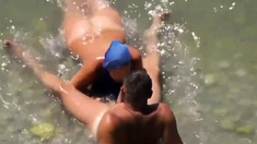 Girl sucks dick her boyfriend in the surf at a public beach